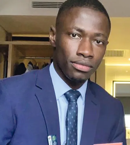Portrait de Momar Talla TINE en costume bleu et cravate